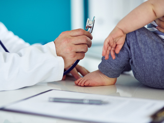 Doctor showing stethoscope to baby